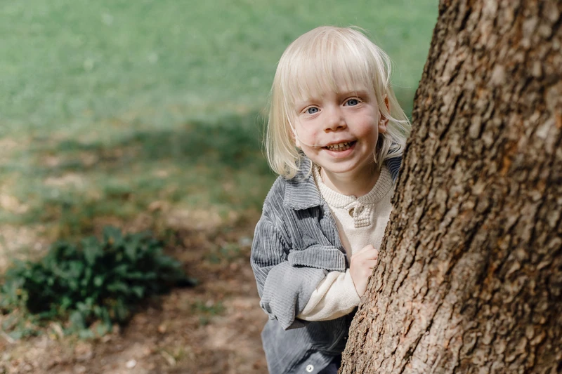 A child behind a tree.