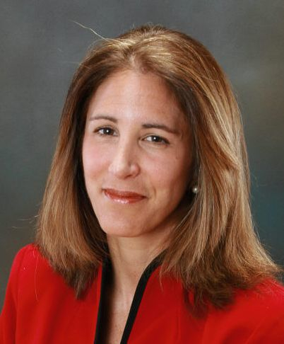 Theresa Cerulli, MD wearing red with a gray background.